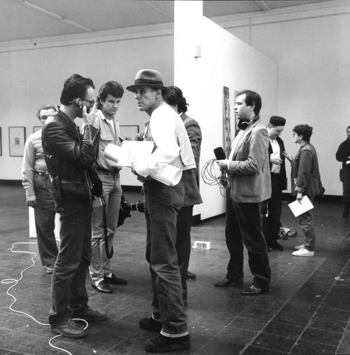 Erika Kiffl (Fotograf*in), "Solidarnosc" - Auktion, Kunstpalast Düsseldorf. Im Vordergrund Joseph Beuys, Johannes Stüttgen, Werner Raeune, ZDF Team. Im Hintergrund: Katharina Sieverding, Halina Jaworski, Jaroslav Adler, 1982