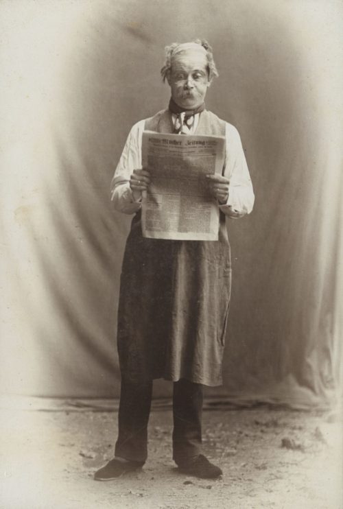 T.J. Dickopf (Künstler*in), Ohne Titel (Mann mit der Wucher Zeitung), ca. 1890