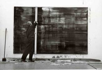 Gerhard Richter mit Rakel vor abstraktem Bild