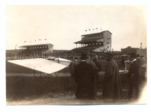 Julius Söhn (Fotograf*in), Personen besichtigen ein Flugzeug, im Hintergrund Tribünen, Flugtag Düsseldorf, 1910er Jahre