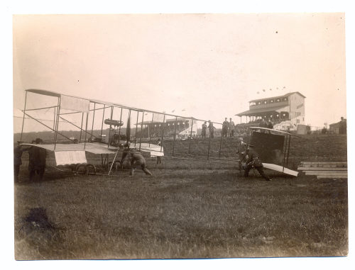 Julius Söhn (Fotograf*in), Doppeldeckerflugzeug wird zum Start (?) geschoben, im Hintergrund Tribünen, Flugtag Düsseldorf, 1910er Jahre