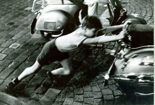 Dirk Alvermann (Fotograf*in), Junge hilft beim Start einer Vespa, Altstadt Düsseldorf, 1961