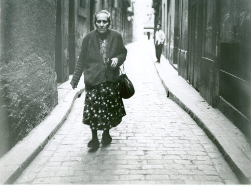 Dirk Alvermann (Fotograf*in), Alte Frau in Gasse, Barcelona, 1957